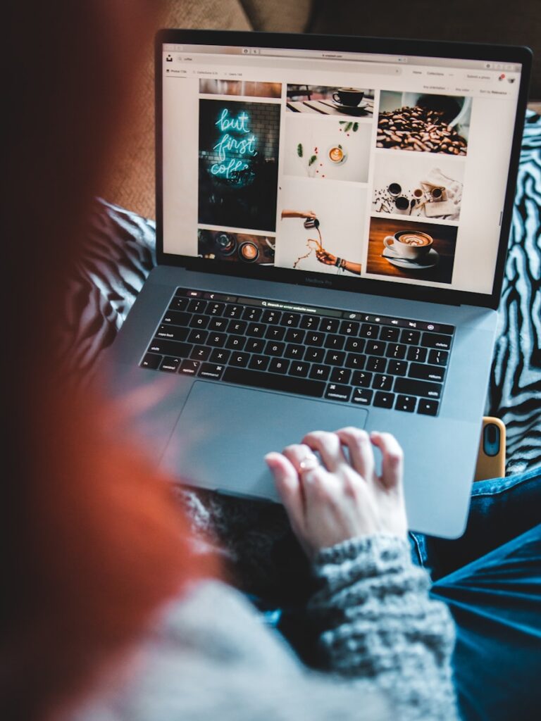 person using macbook pro on white and black textile